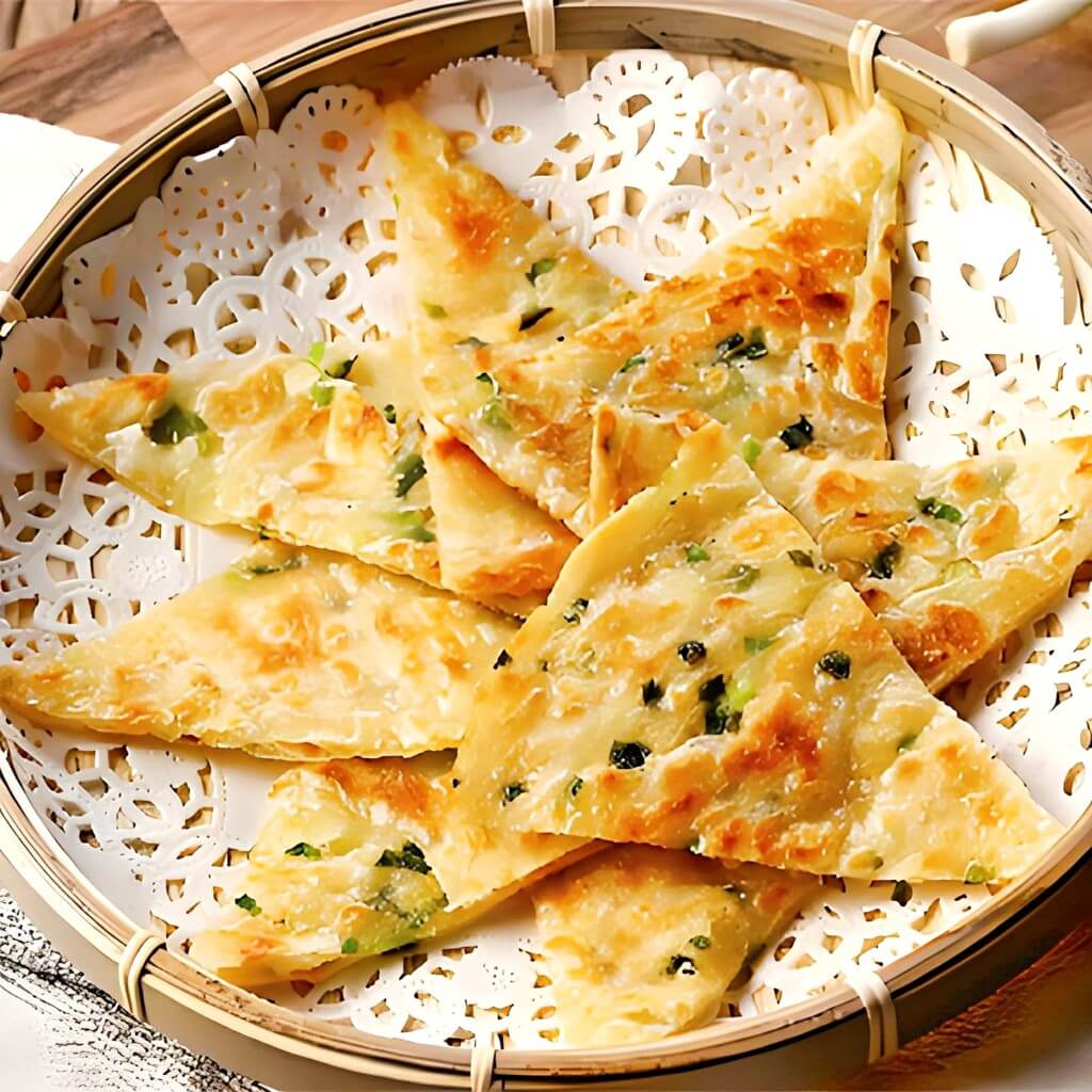 Clătite chinezești cu ceapă, aurii și crocante, preparate vegan fără ou și sos. Servite la restaurantul Jin Ding din Sector 2, București. Preț 28 LEI/100g.