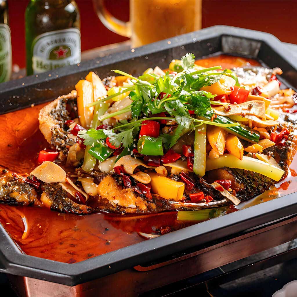 Pește crap la grătar cu sos picant, un preparat cu crap proaspăt gătit la grătar, servit cu legume și sos picant, la restaurantul Jin Ding din Sector 2, București. Preț 188 LEI/1 kg.