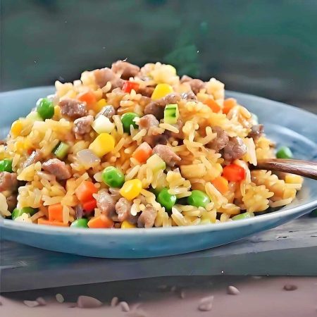 Orez prăjit cu vită, mazăre și ou, un preparat tradițional chinezesc gustos și sățios, servit la restaurantul Jin Ding din Sector 2, București. Preț 25 LEI/250g.